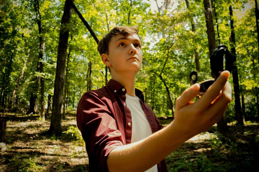Boy with compass in the forest - trauma therapy for children can show pathways
